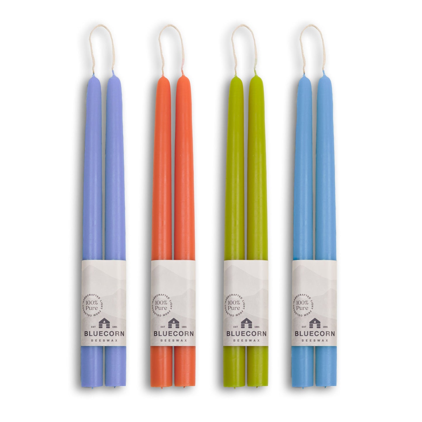 Set of four colorful candles in their packaging on a white background