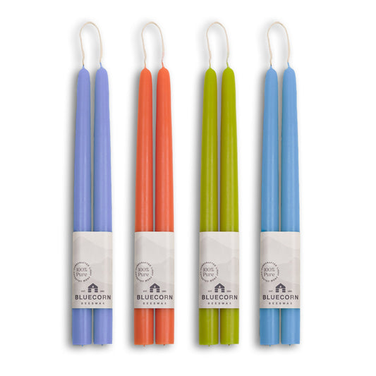 Set of four colorful candles in their packaging on a white background