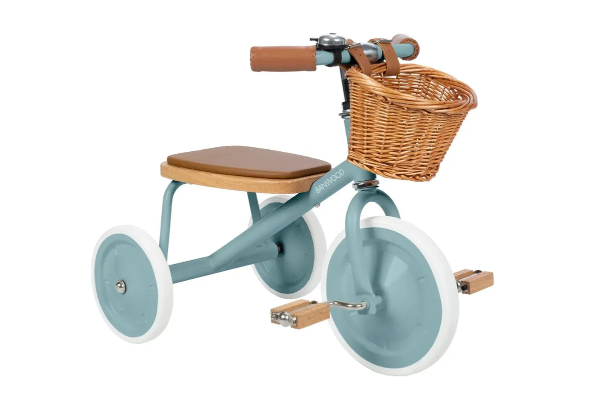 Teal children's tricycle with a brown seat and wicker basket on a white background