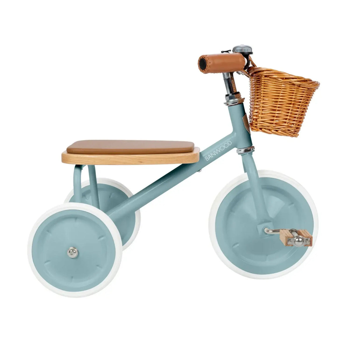 A children's tricycle in teal with a natural wood seat and handlebar grips, a brown wicker basket, and white-walled wheels