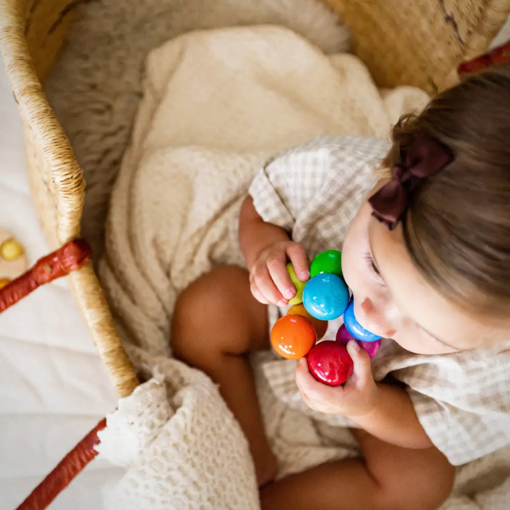 Infant playing with colorful baby toy