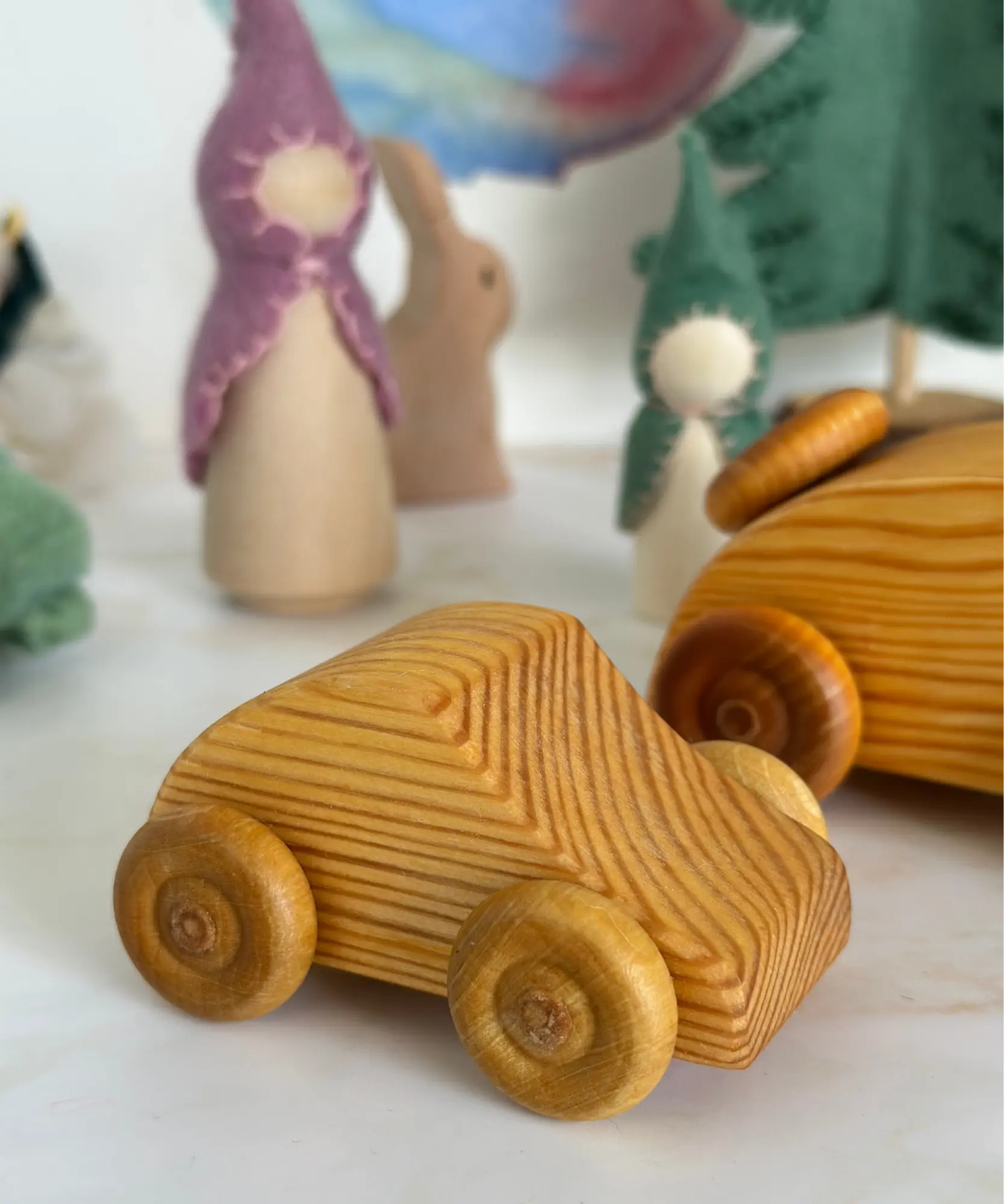 Wooden Telleby toy car from Sweden on a white surface with blurred background