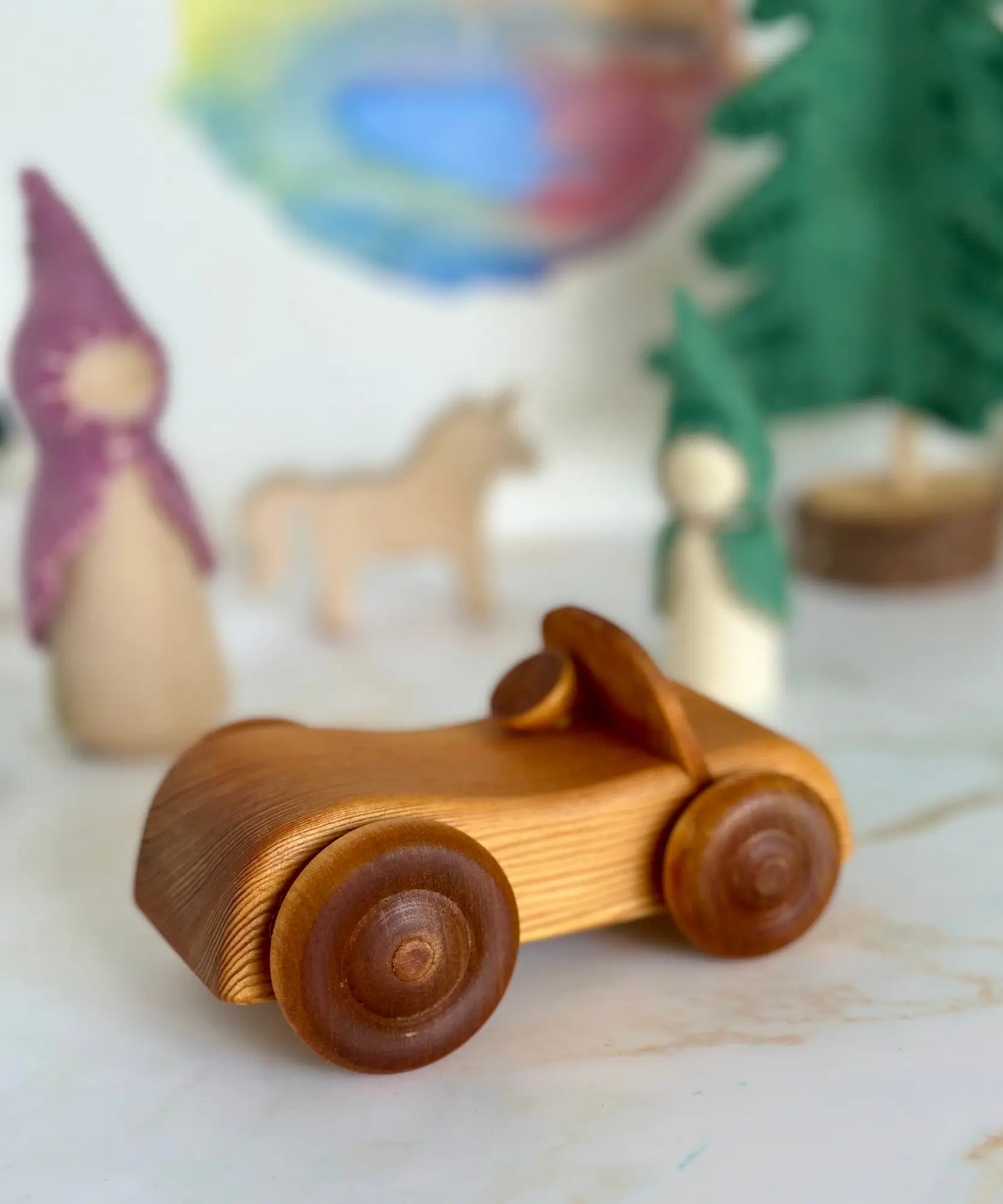 Wooden toy car on a marble surface with blurred background