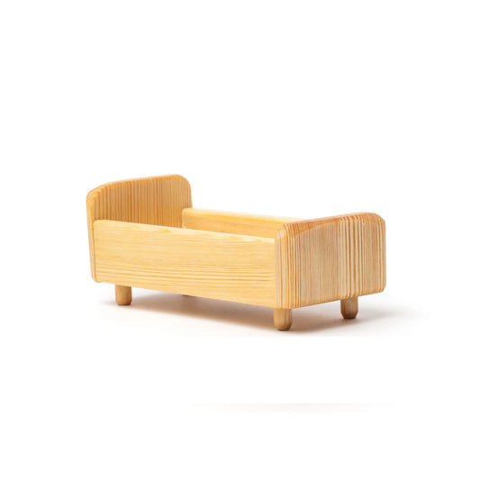 Wooden dollhouse bed on a white background