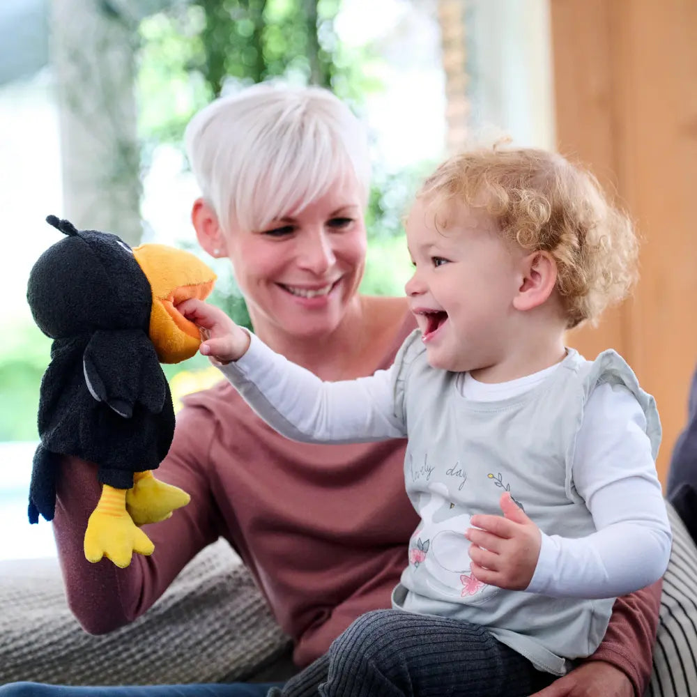 Toddler enjoying interactive storytelling with Theo the Raven puppet