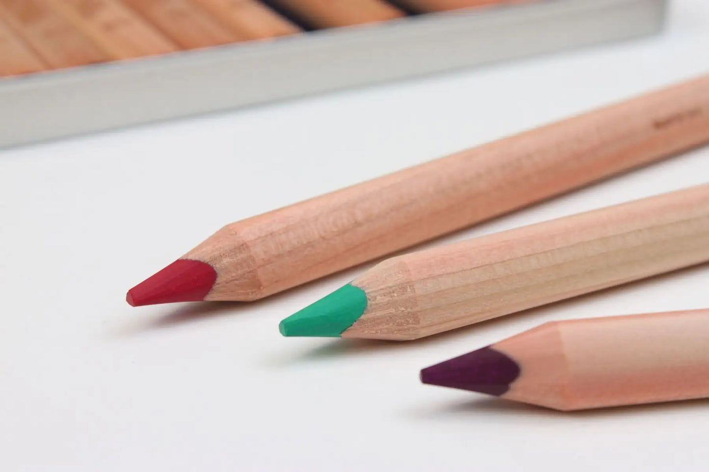 close up of thick core colored pencils showing rich pigment tips and hexagonal wood barrels