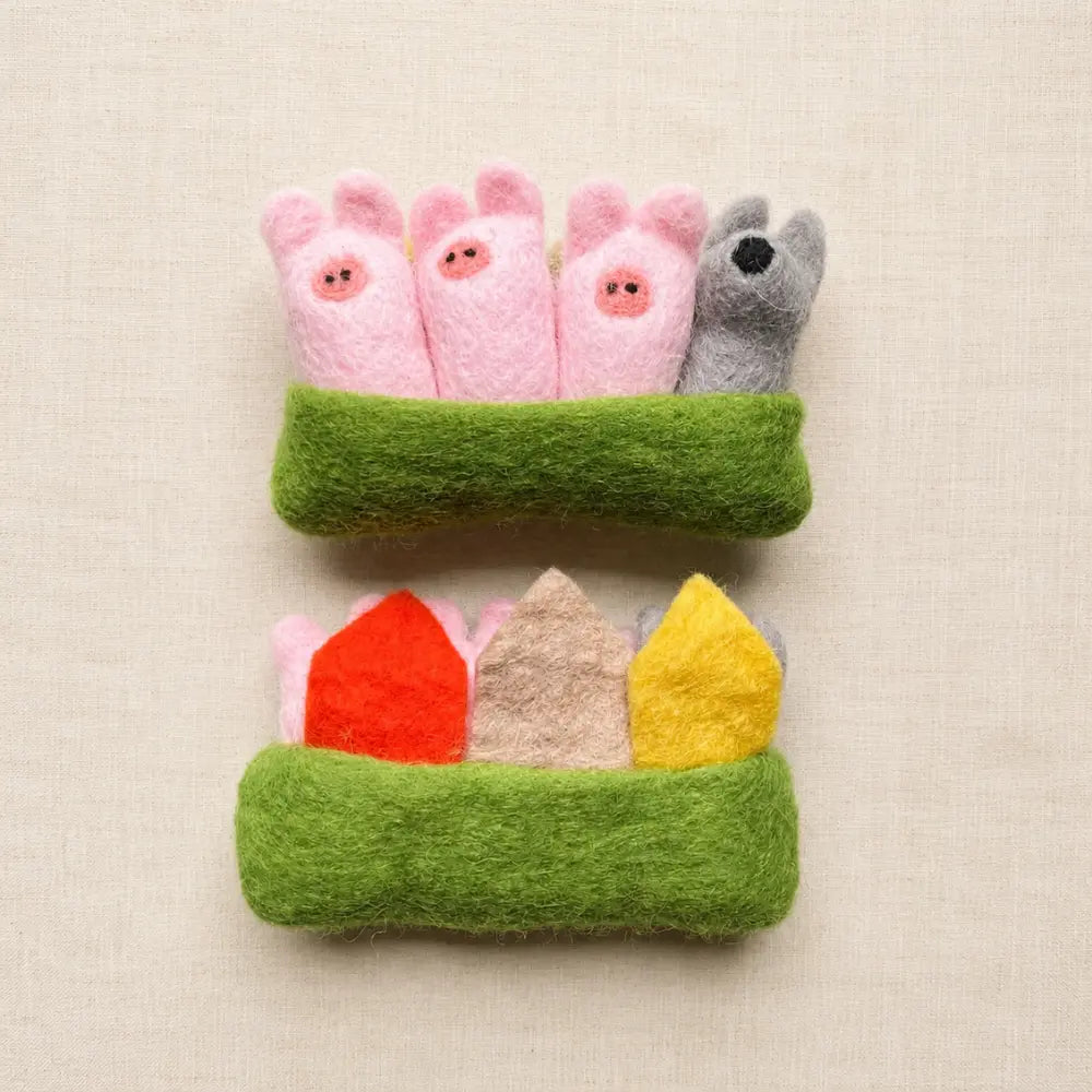 Three Little Pigs felt pocket play set with three pigs and wolf tucked inside a green felt pouch.