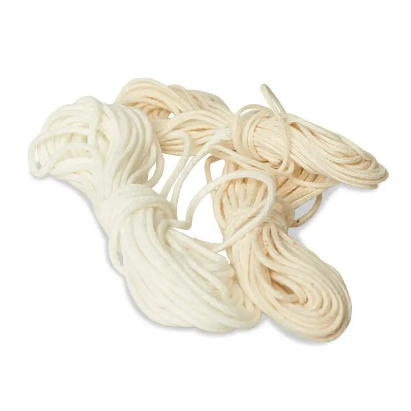 Bundle of three cotton wicks on a white background