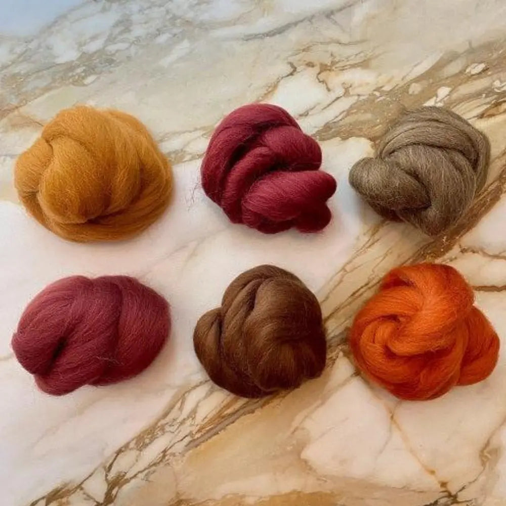 Six Toasted Terra Cotta Wool Top Bundle for Spinning on marble background