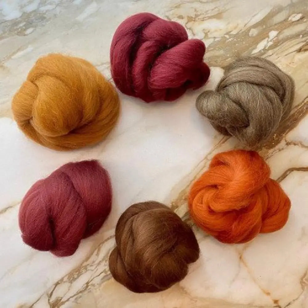 six Toasted Terra Cotta Wool Top Bundle for Spinning in a circle on marble