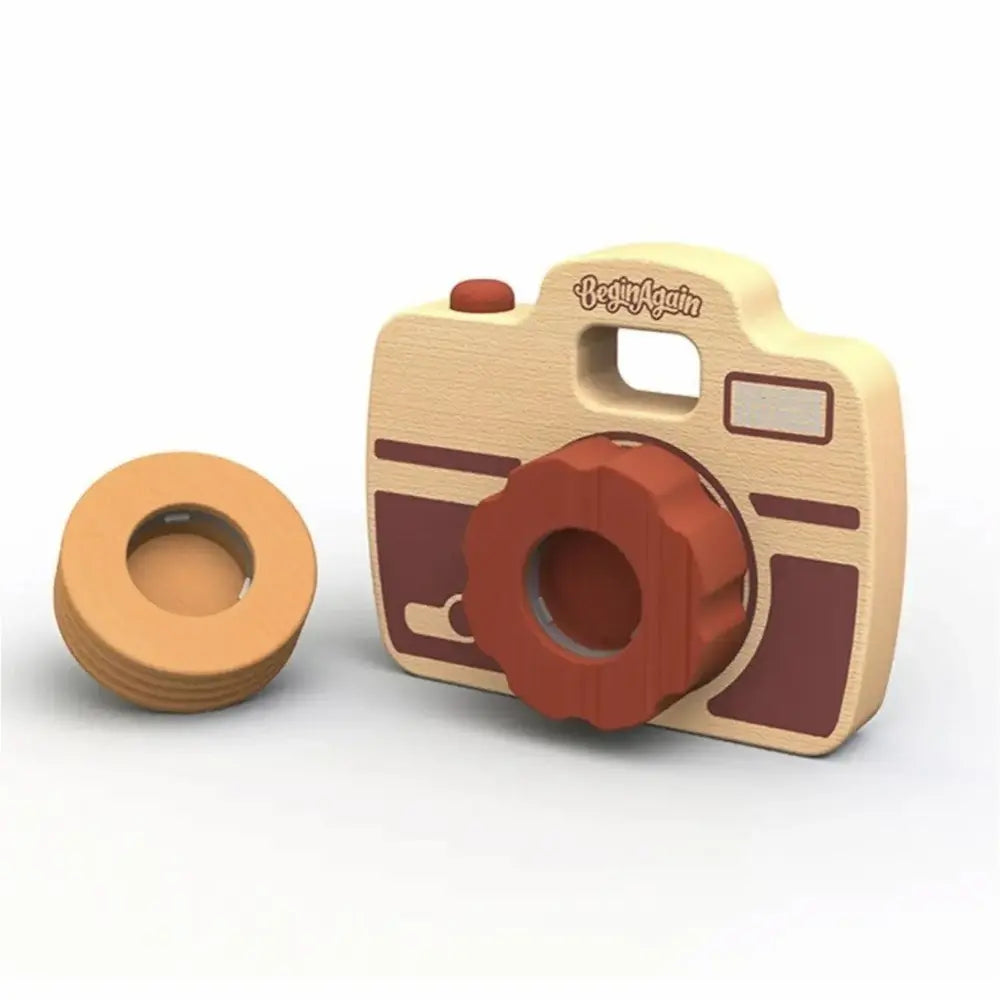 Wooden toy camera-shaped toy with a smaller round wooden object on a white background