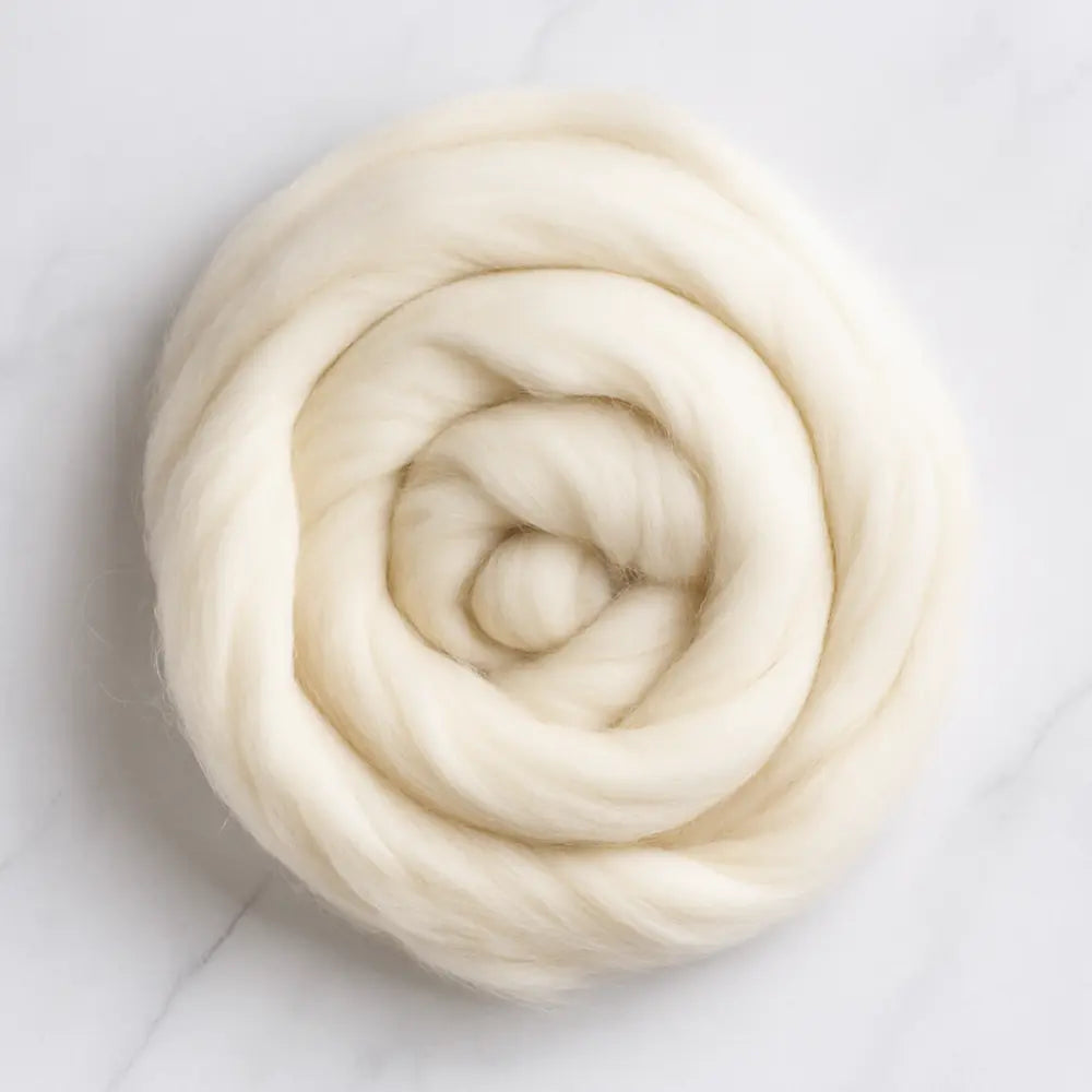 Coiled skein of cream-colored wool on a light gray background