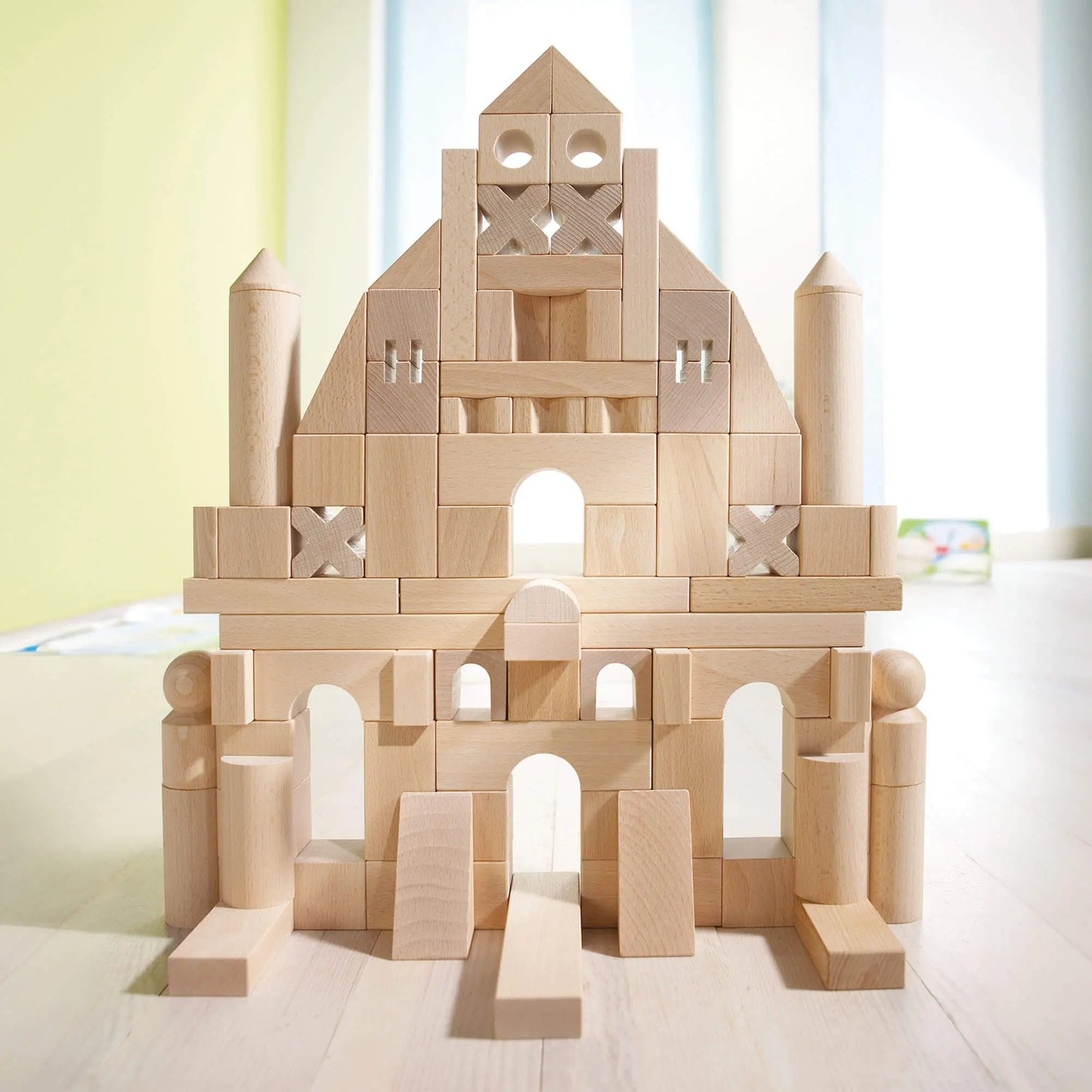 Montessori wooden blocks in a castle formation on a light surface with a blurred background