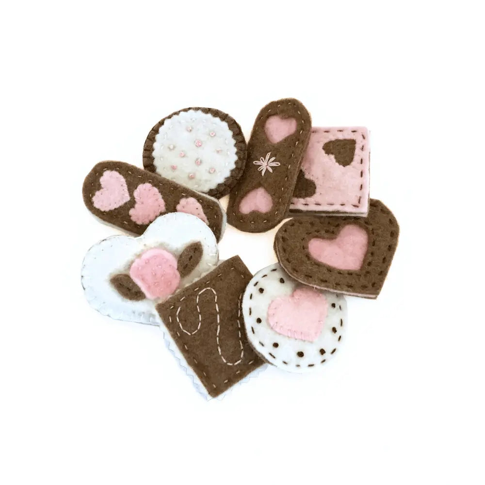Set of felt cookies with pink hearts on a white background