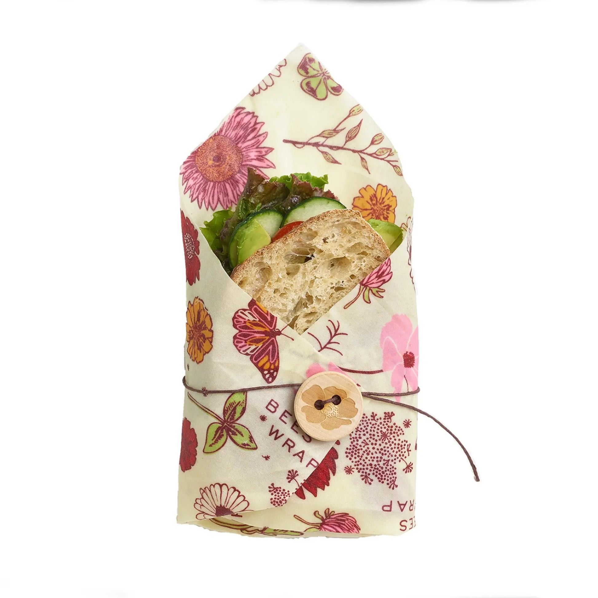 Sandwich wrapped in a floral-patterned vegan wax food wrap on a white background