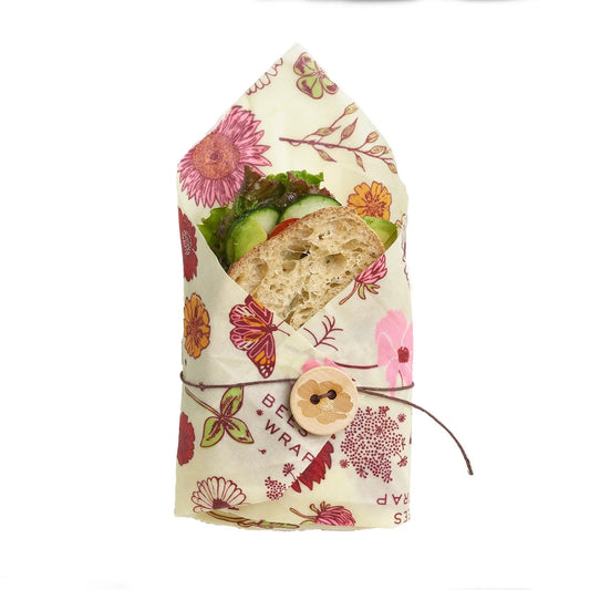 Sandwich wrapped in a floral-patterned vegan wax food wrap on a white background