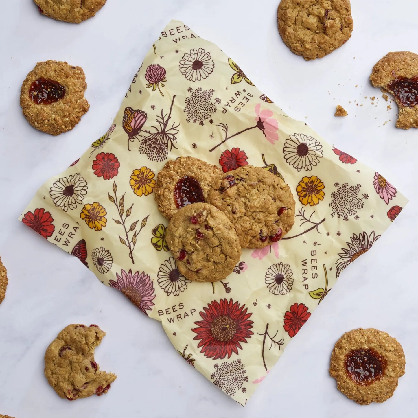 Cookies on a floral vegan wax wrap with additional cookies around on a white background