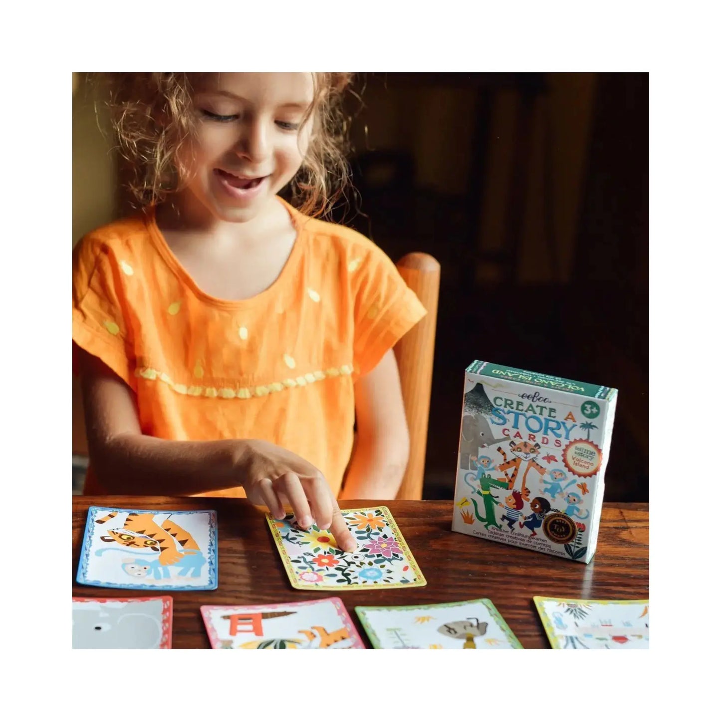 Child using Volcano Island story cards on table and pointing to a card