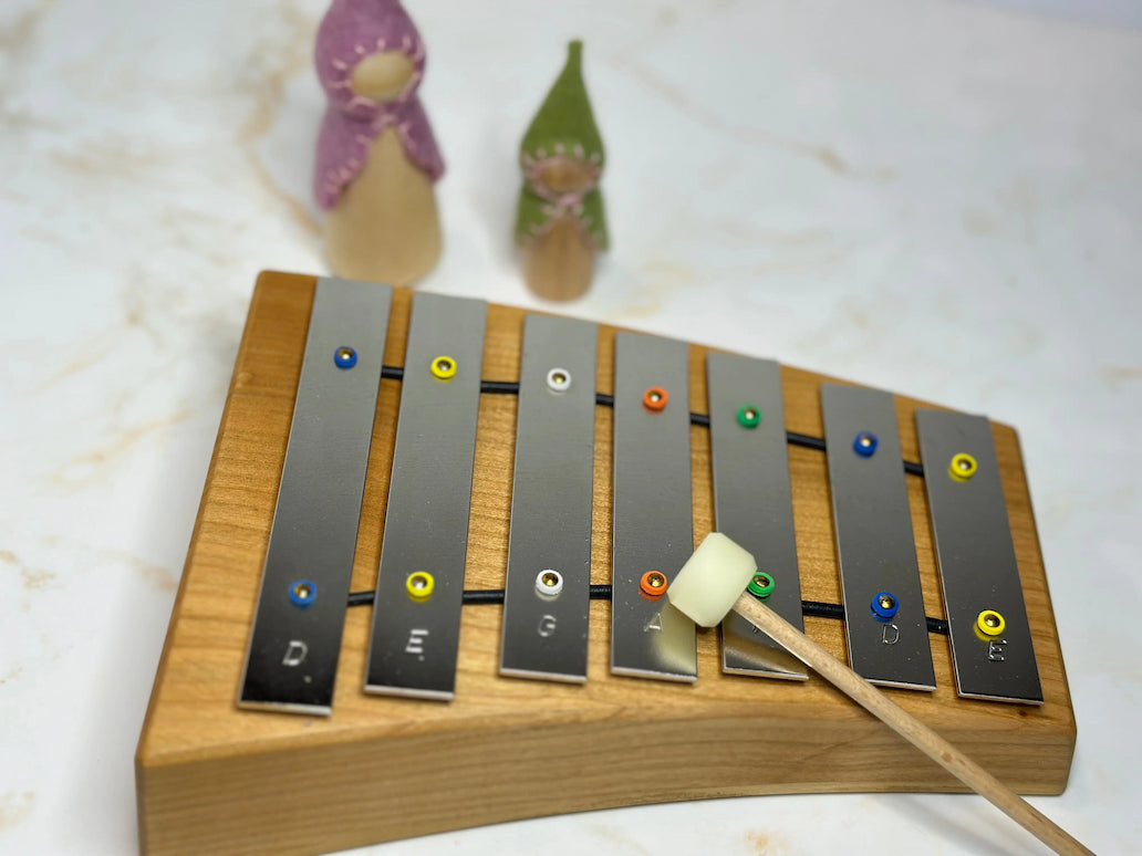 Wooden glockenspiel and mallet with on a light background