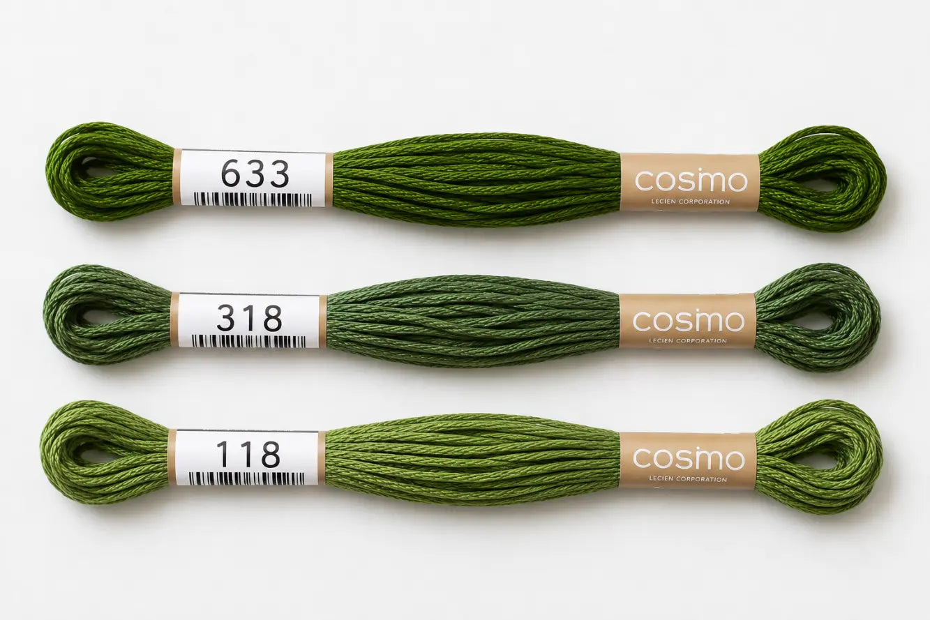 Three skeins of green embroidery floss with 'cosmo' branding on a white background