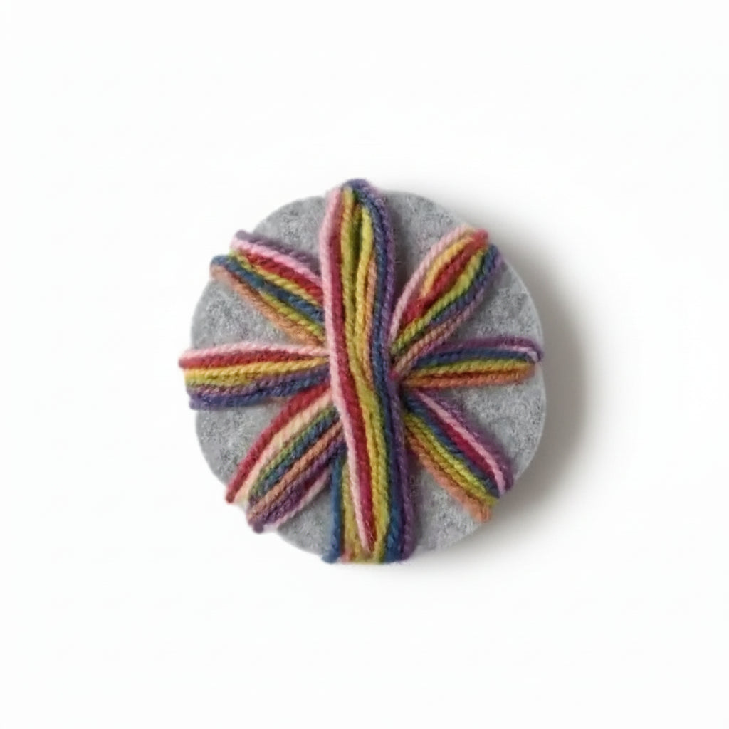rainbow yarn wrapped around a gray wool felted braiding star