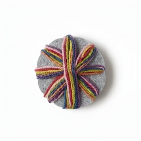 rainbow yarn wrapped around a gray wool felted braiding star