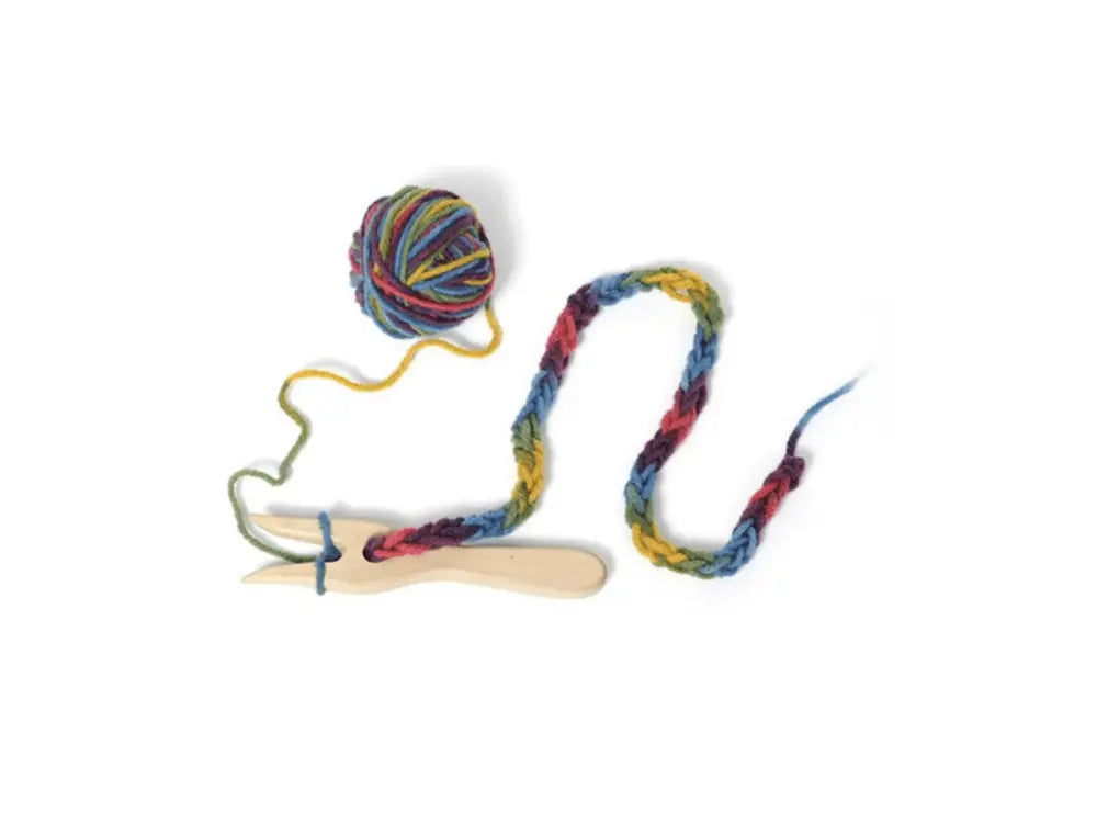 Colorful yarn ball with a wooden tool on a white background