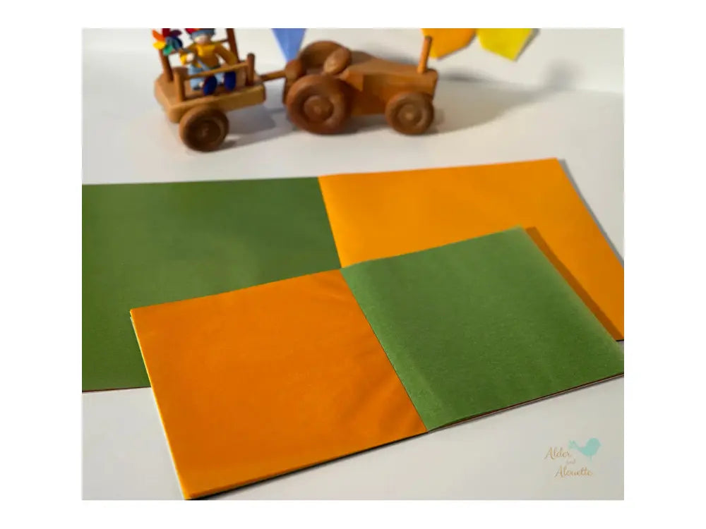 Colorful kite paper with wooden toy truck on a white surface