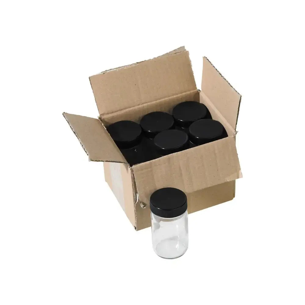 Cardboard box with black lidded glass paint jars on a white background