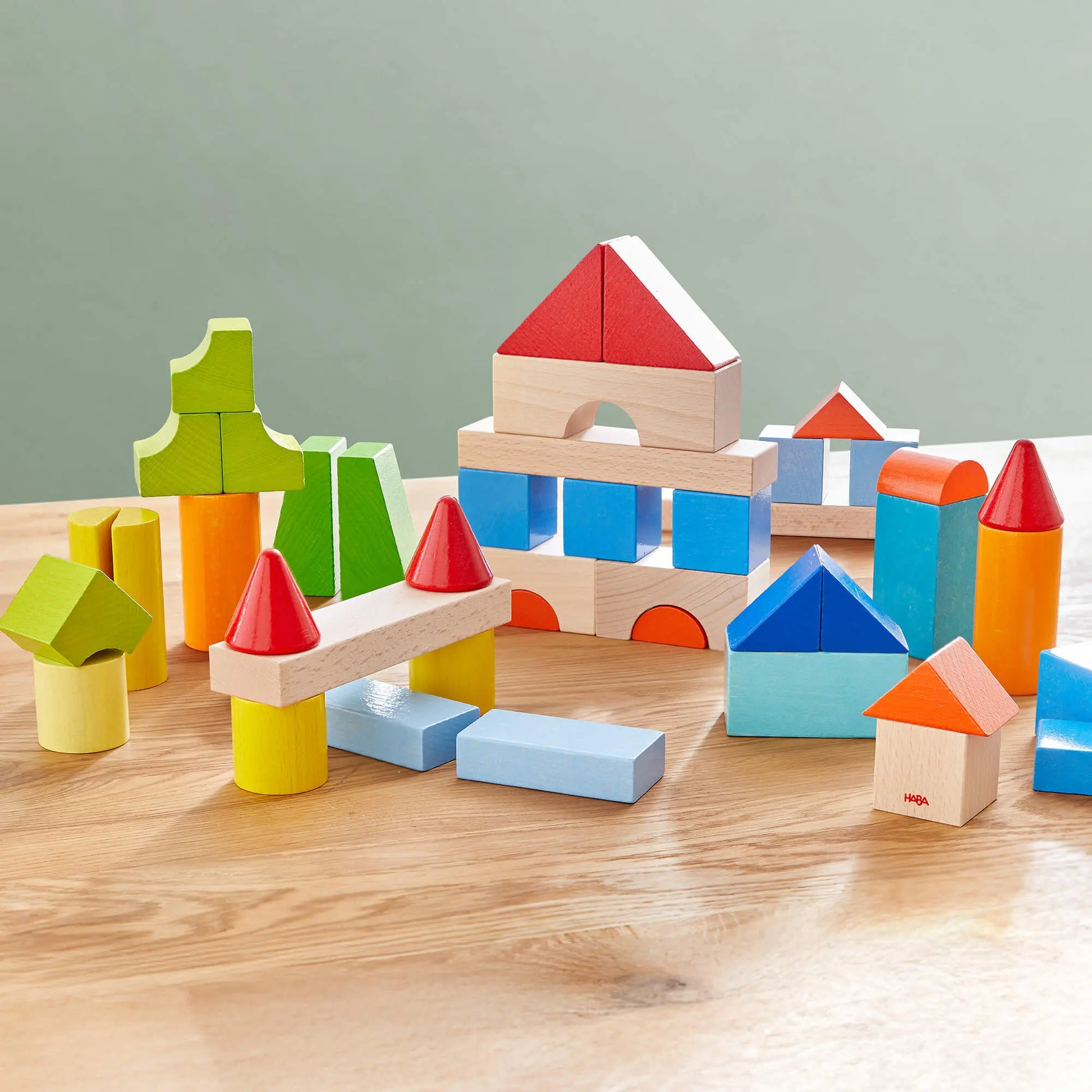 Colorful wooden building blocks on a wooden surface with a light gray background