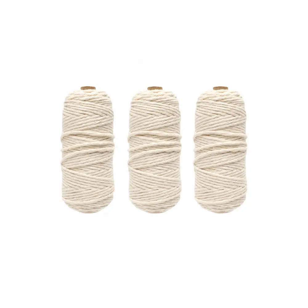 Three skeins of cotton warp string for looms on a white background
