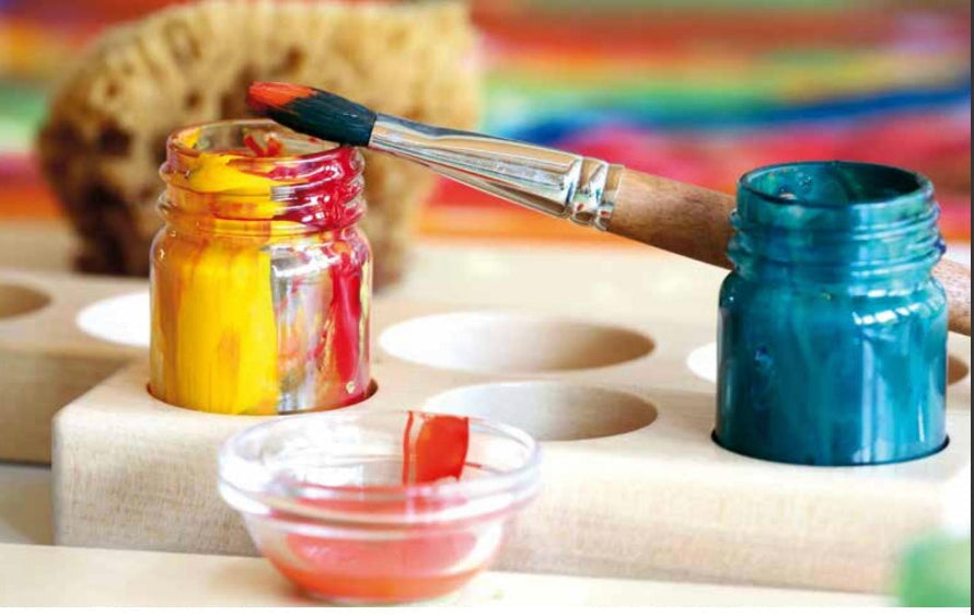 Wooden paint jar holder with jars of watercolor paint and paintbrush