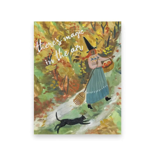 Halloween illustration of a friendly witch with a black cat in an autumn forest, with text 'there's magic in the air'.