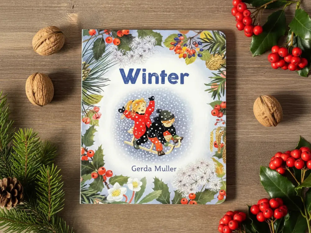 Book titled 'Winter' by Gerda Muller on a wooden surface with winter-themed decorations.