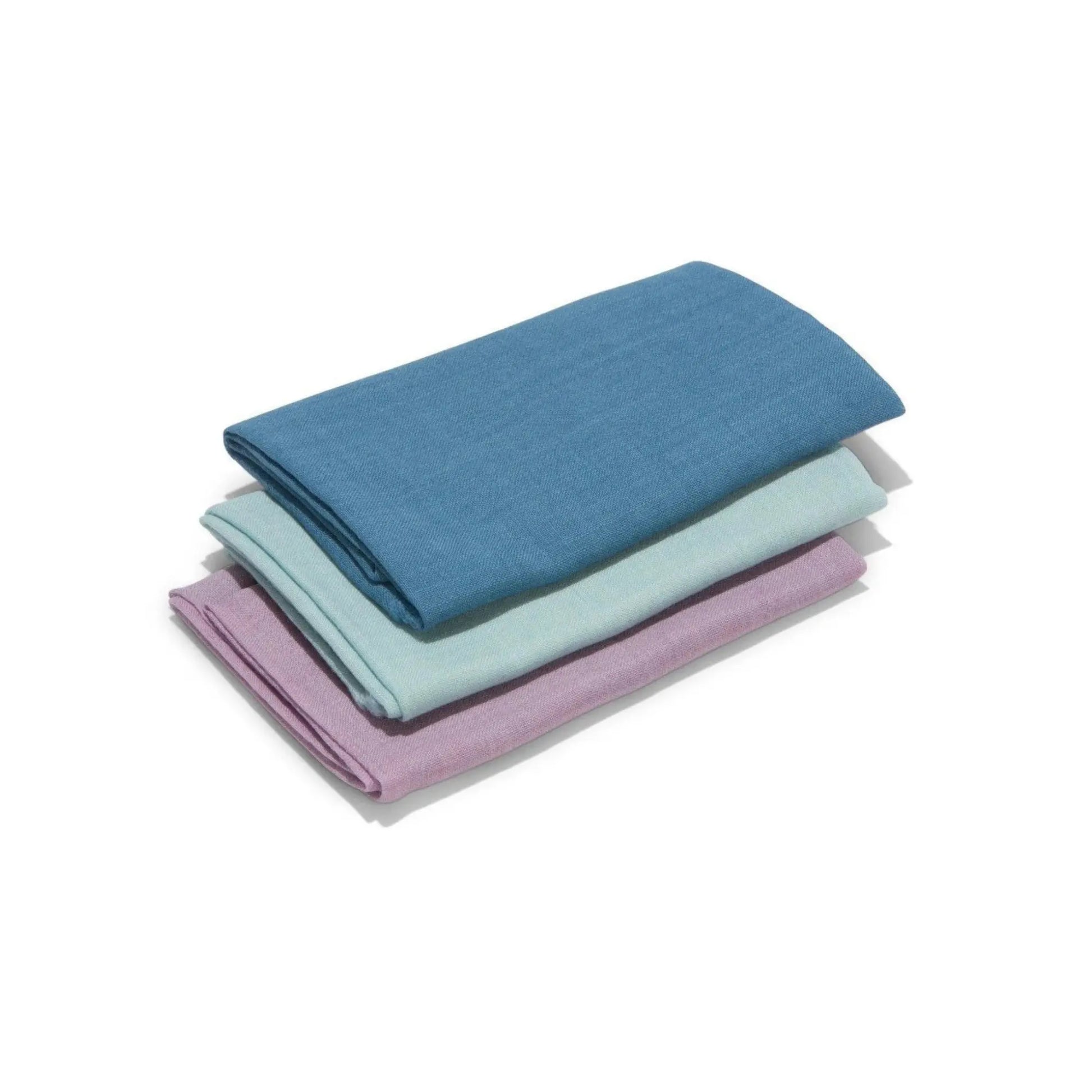 Stack of folded three wool fabrics in blue, purple, and light blue on a white background