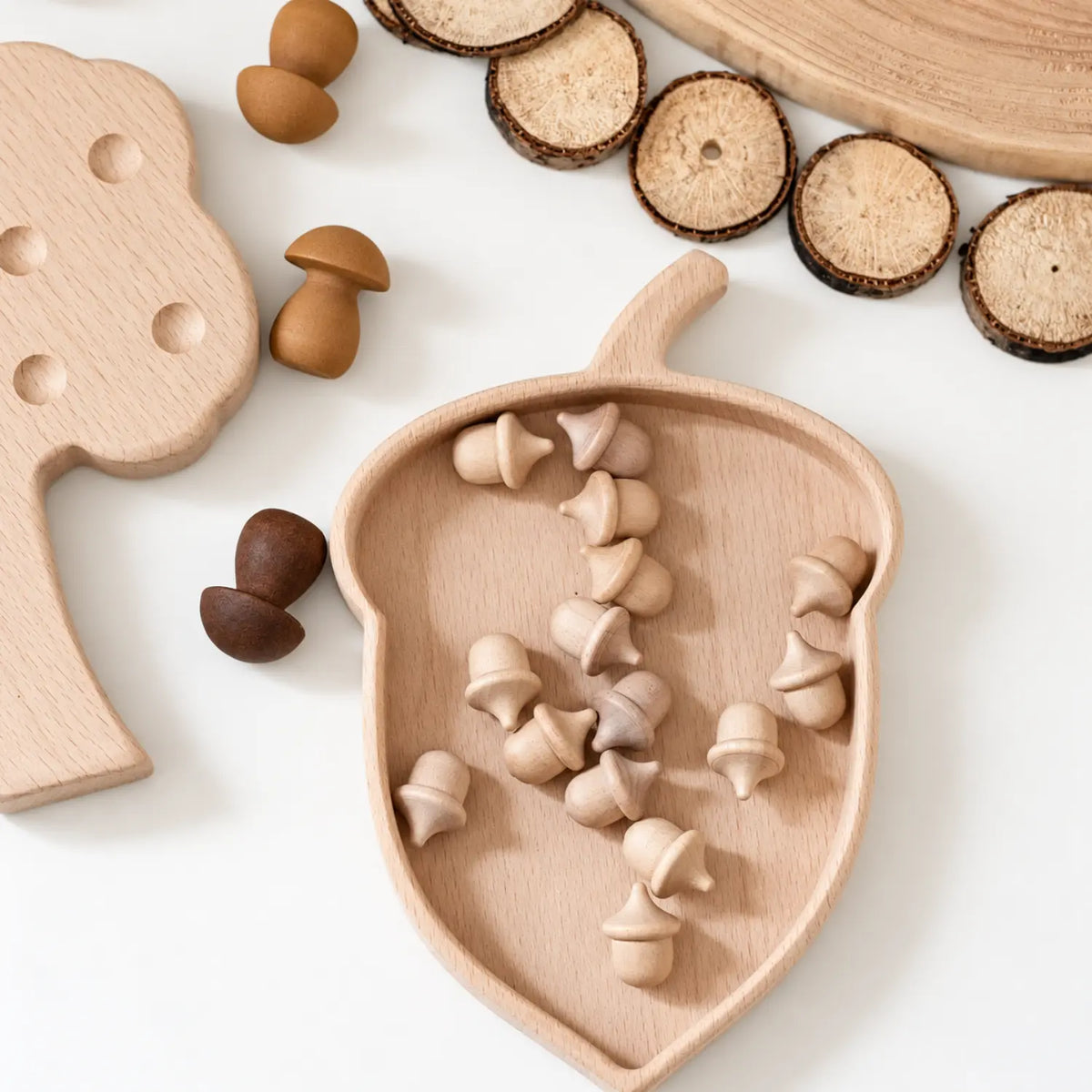 Unfinished wooden acorns with wooden trays and natural craft materials