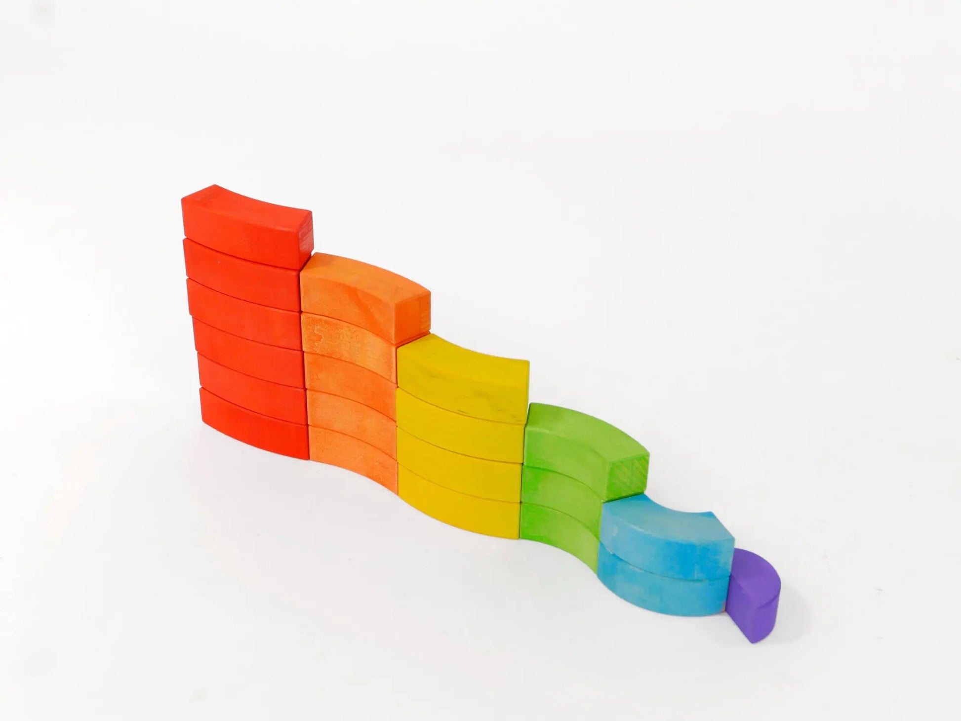 Colorful wooden blocks stacked in a wavy pattern on a white background