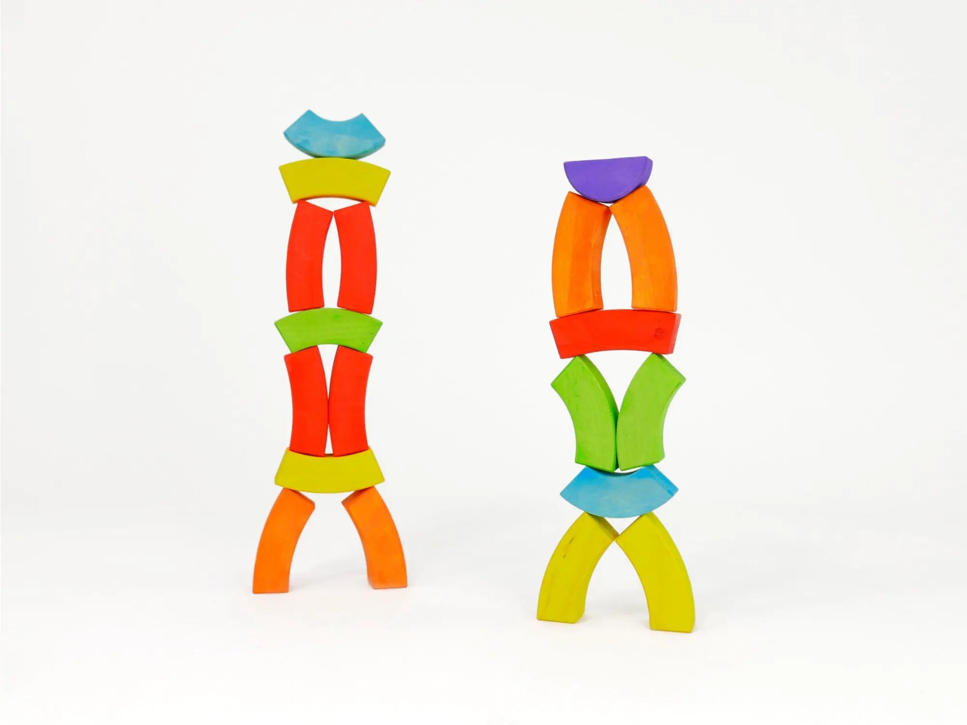 Two colorful toy structures made of curved pieces on a white background
