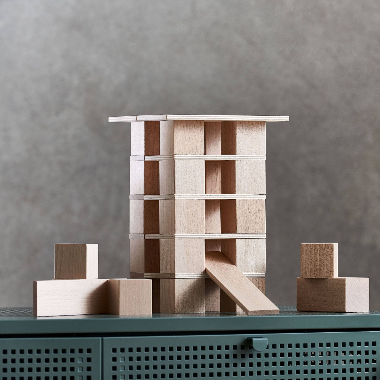 Multi-level wooden building block tower with interior spaces and stacked panels