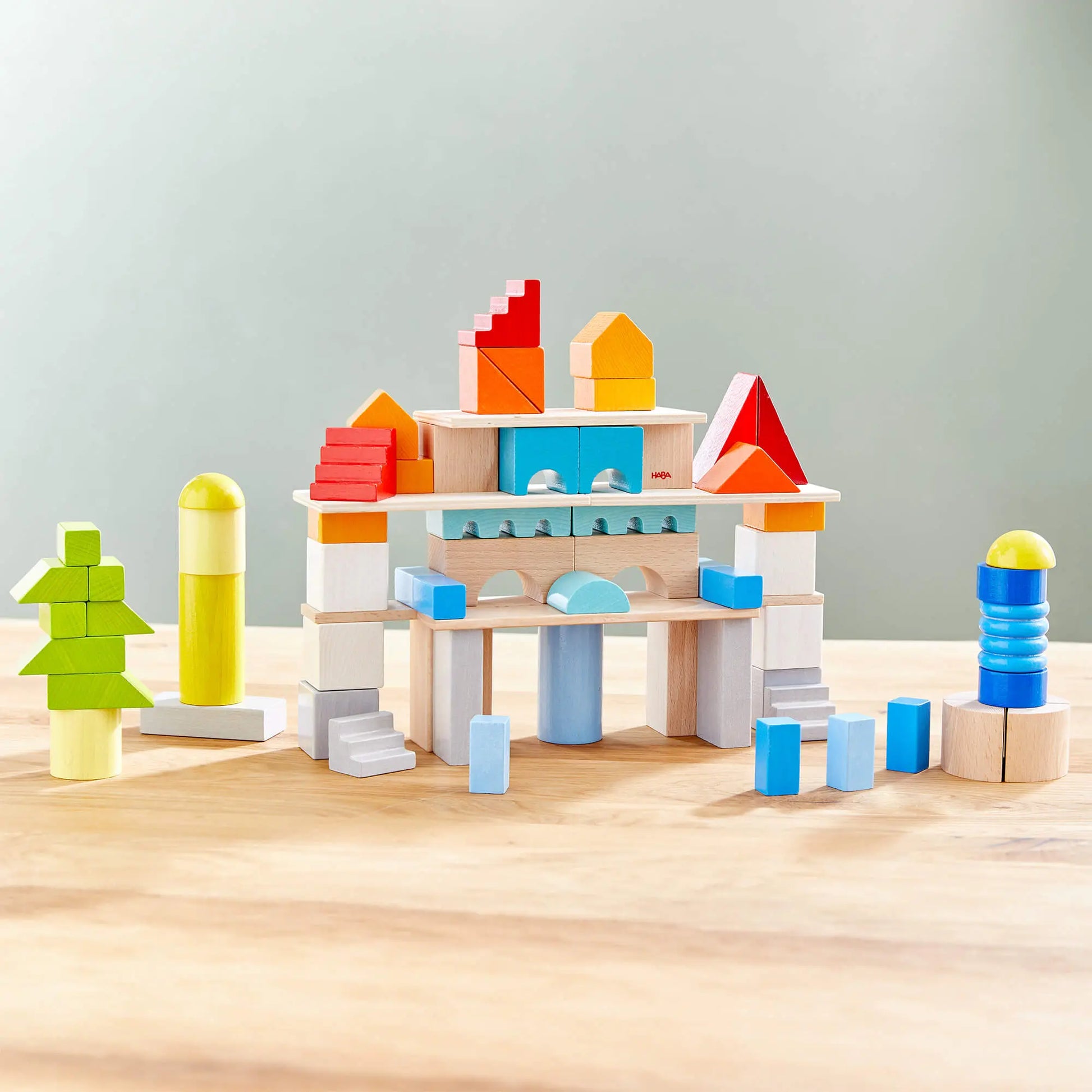 Colorful wooden building blocks on a wooden surface with a light gray background