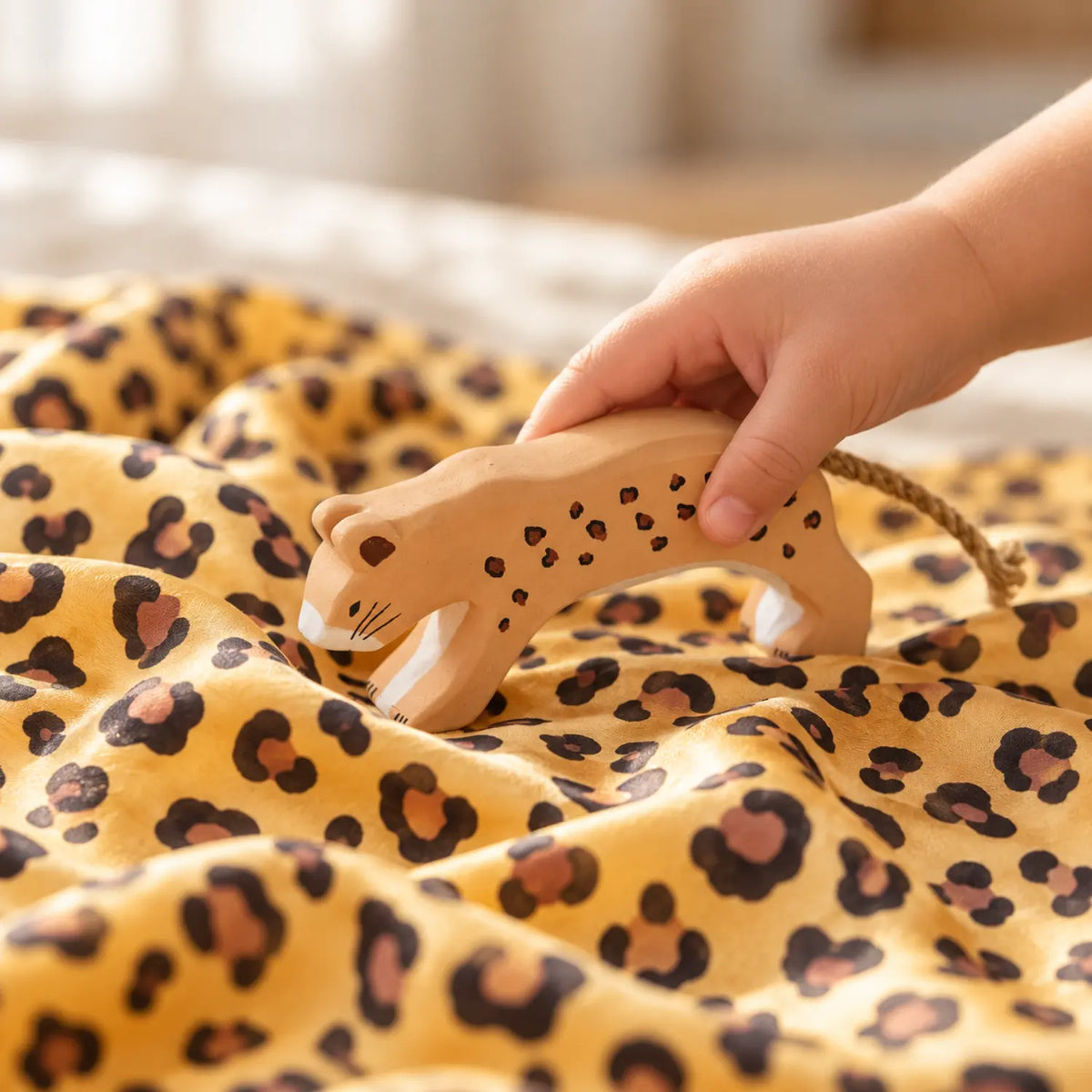 Sarah’s Silks hand-painted wooden cheetah toy on a cheetah playsilk