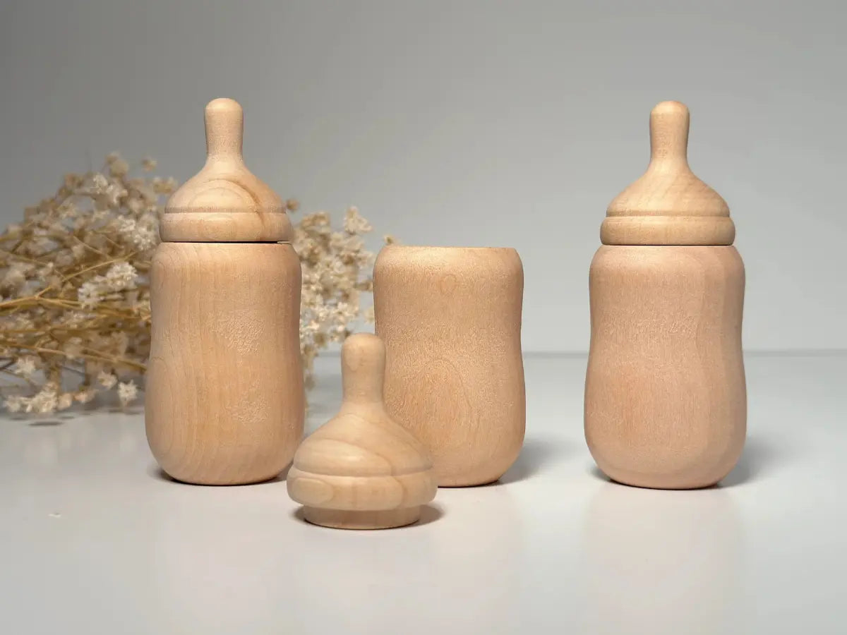 Set of wooden baby bottles on a neutral background