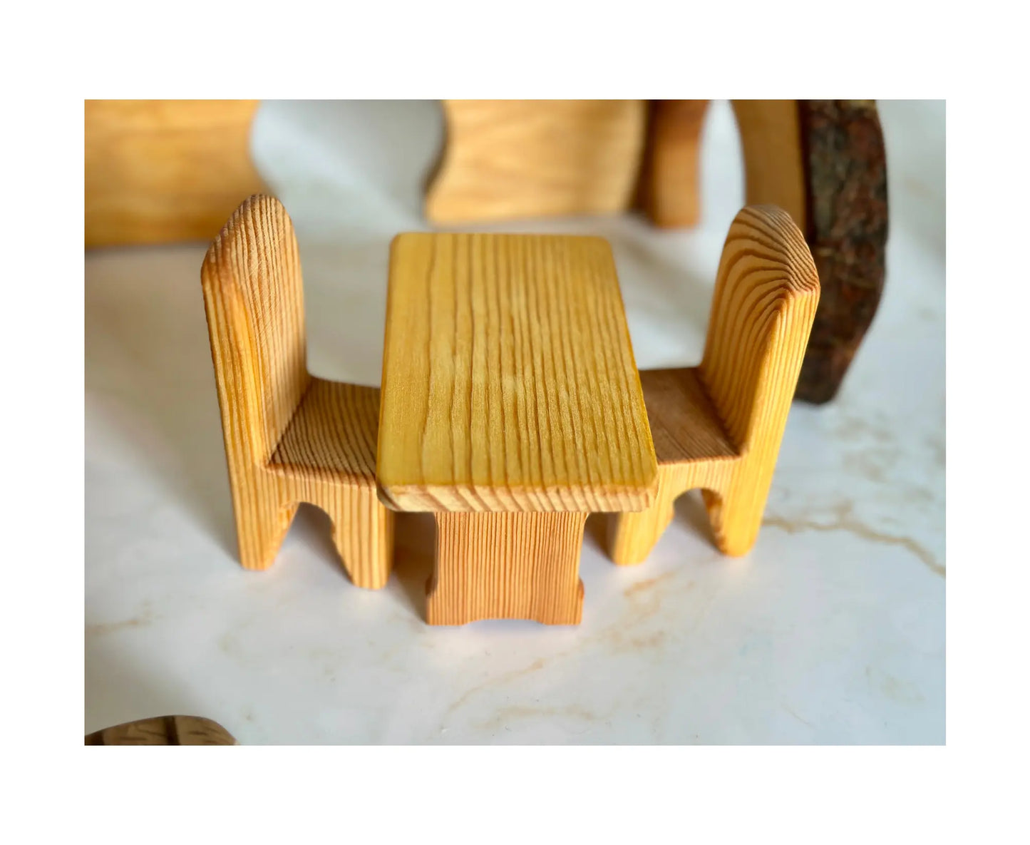 Side view of wooden dollhouse table and chairs set with smooth natural finish