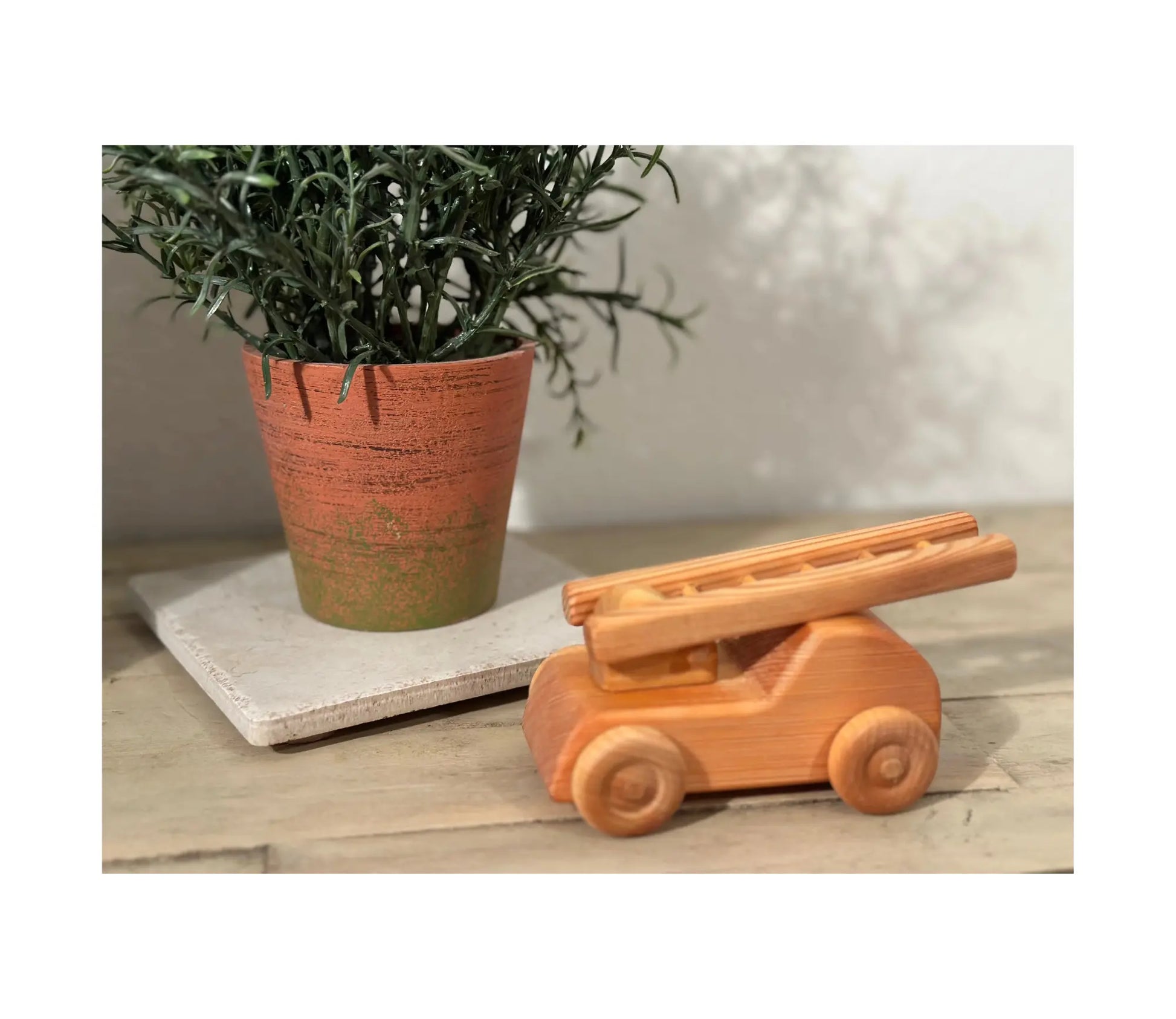 Wooden fire truck with ladder in a small-world play scene for imaginative storytelling