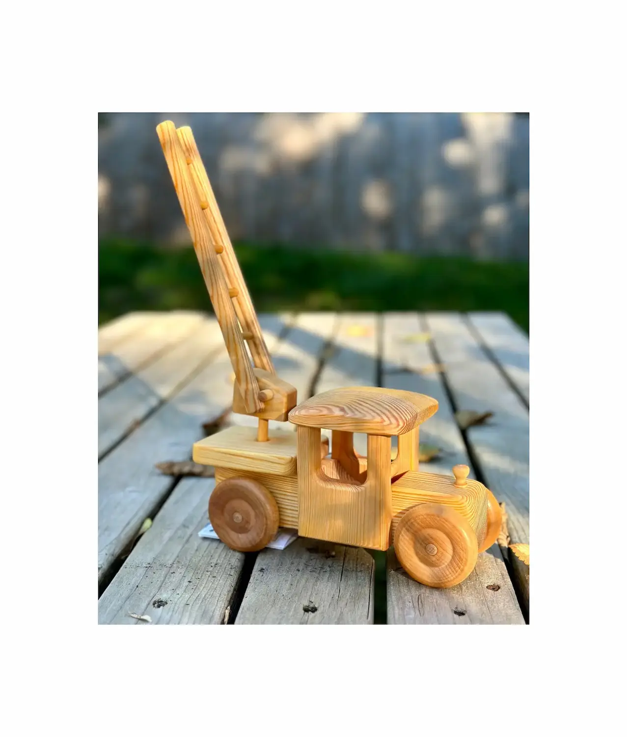 Wooden toy firetruck with ladder raised showing extendable ladder feature and craftsmanship