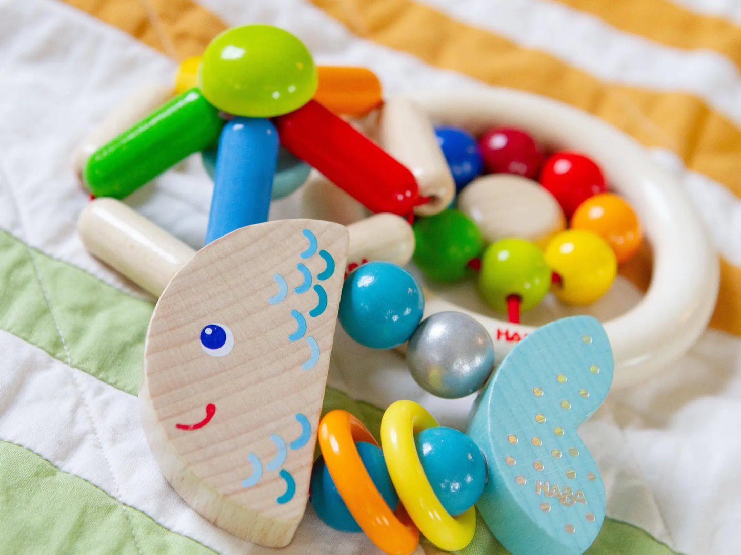 Colorful baby toy with beads and textures on a soft surface