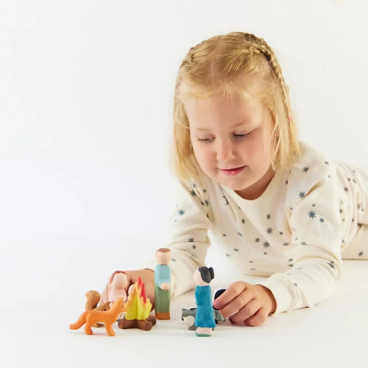 Child playing with a Sarah’s Silks wooden fox and figures during woodland small-world play