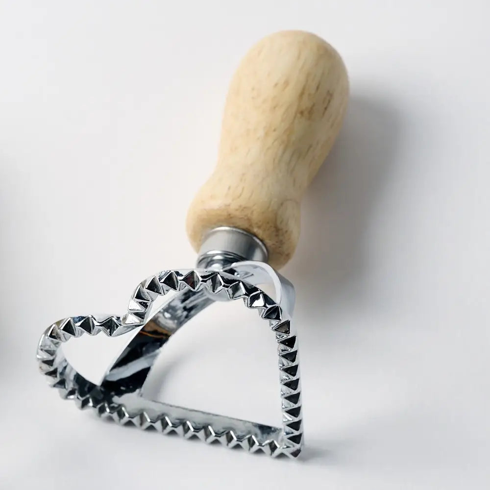 Close-up of wooden and metal heart dough cutter for play dough, clay, and sensory play
