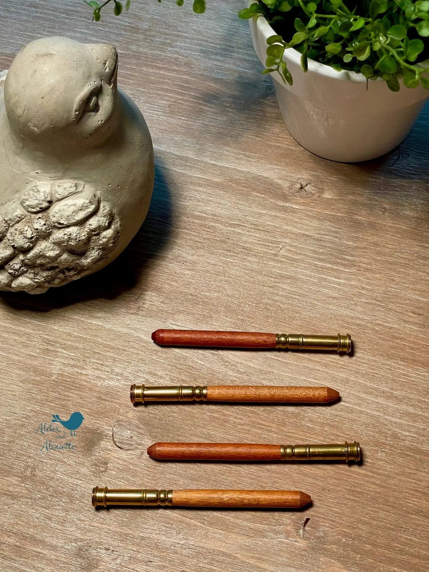 wooden pencil extenders on table with natural materials showing simple tool for extending thick pencils in home or classroom
