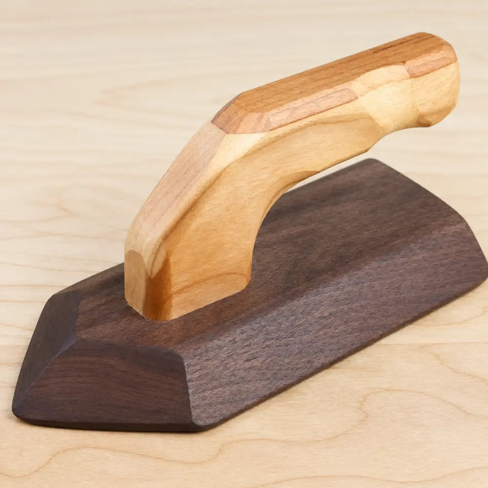 Wooden play iron showing cherry wood handle, walnut base, and natural wood grain